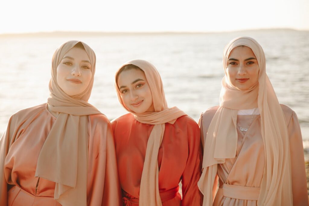 pexels-photo-8995940 Three smiling women in hijabs enjoying a sunny day at the beach.